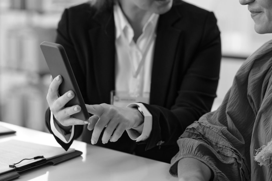 Specjalistka Kancelarii JASNA 3 omawiająca z klientką informacje wyświetlane na smartfonie.